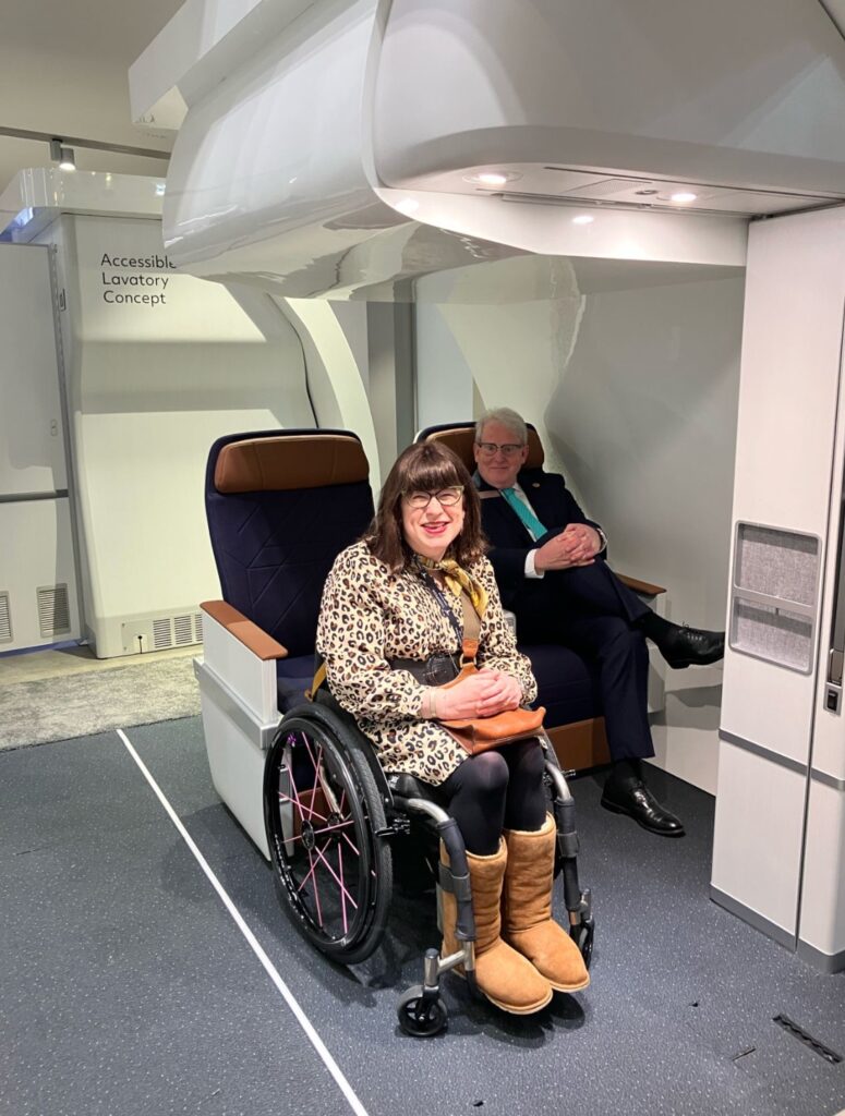 Collins Aerospace's Prime+ wheelchair tie-down and passenger pleasing monument for a disabled person to remain in their own chair on board. Mary Doyle tries it out on the AIX 2025 show floor.